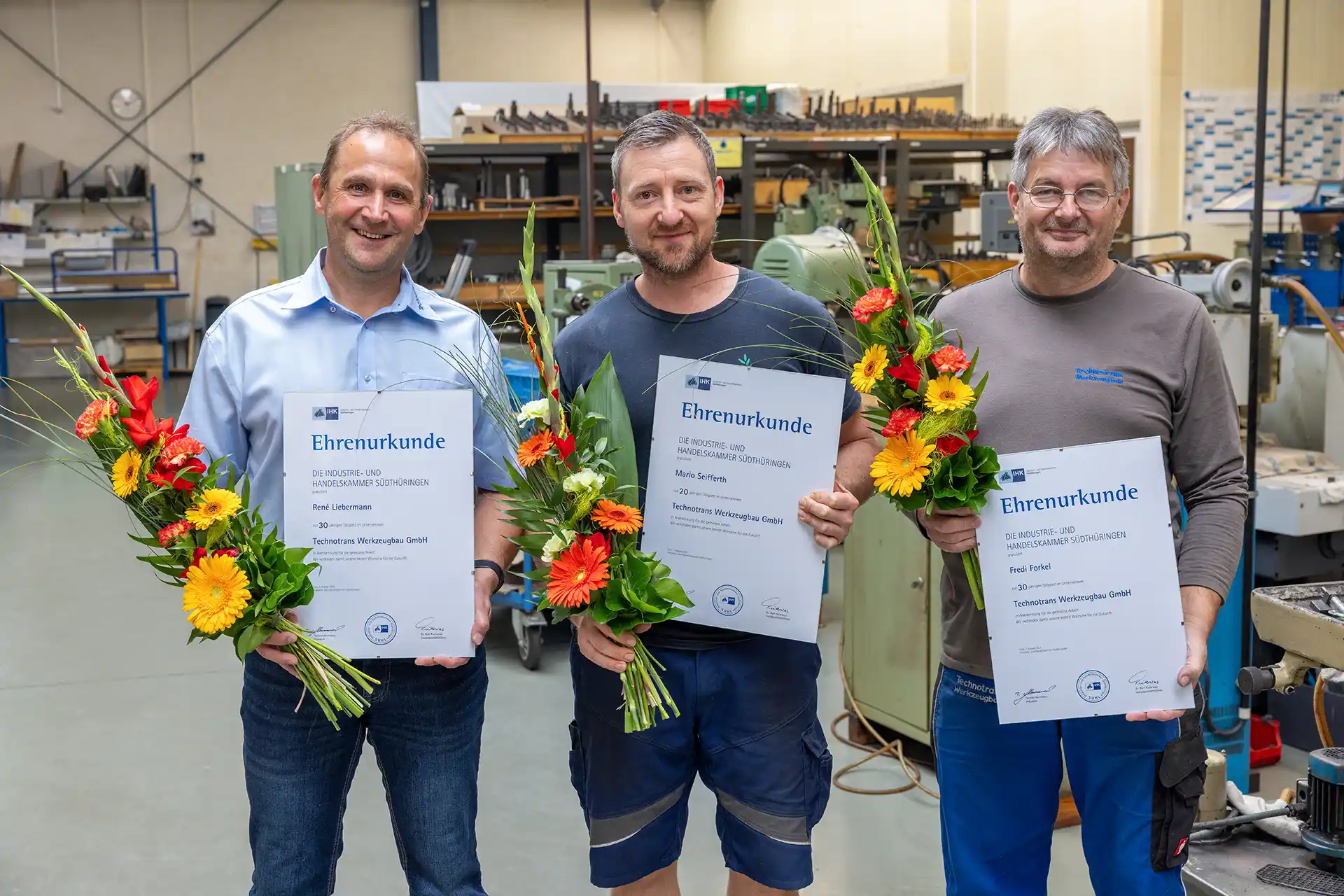 René Liebermann, Mario Seifferth und Fredi Forkel jeweils mit Ehrenurkunde und einem Blumenstrauß zum Jubiläum